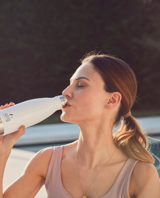 Woman drinking through a water bottle